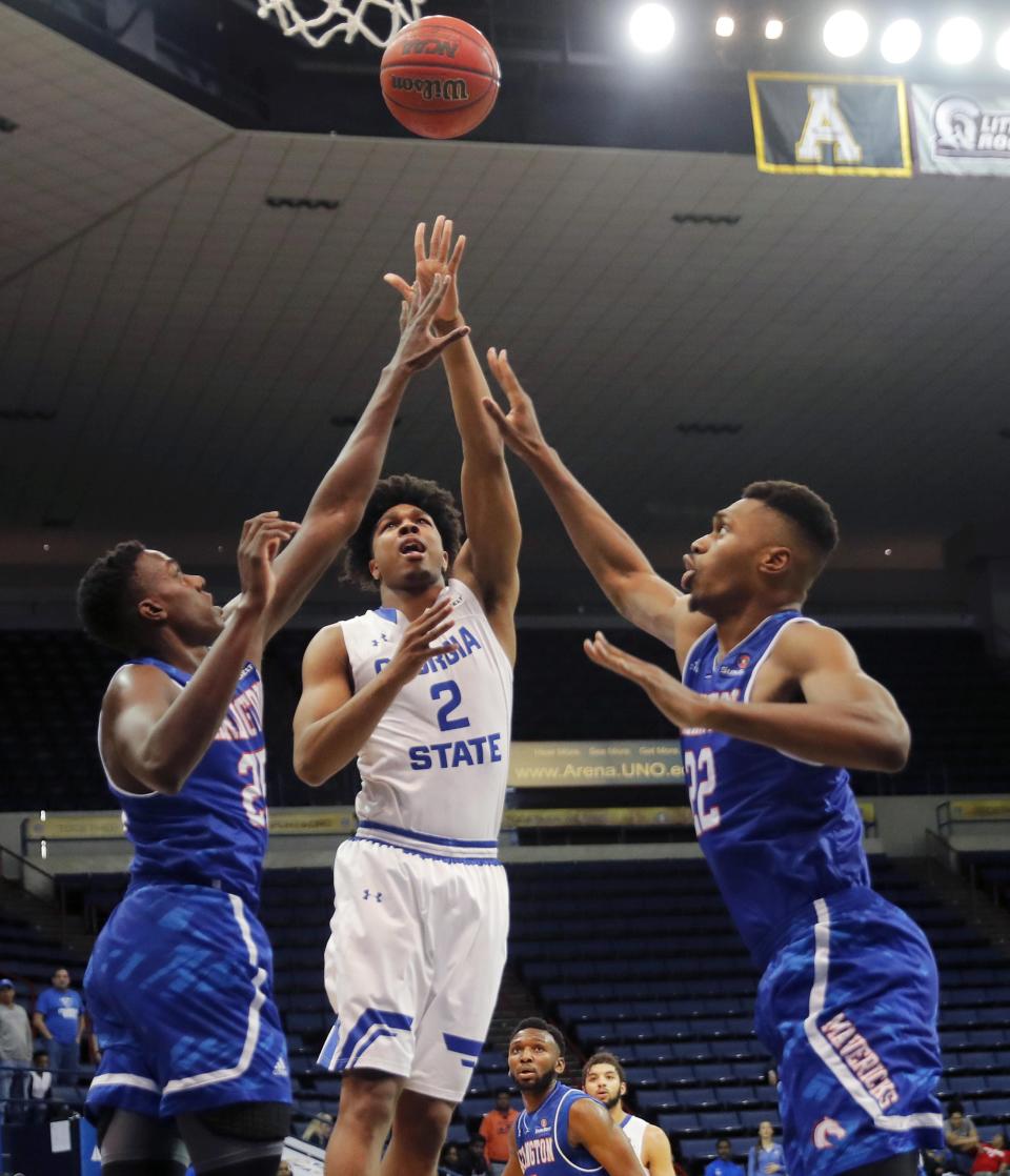Georgia State forward Malik Benlevi (2) shoots between Texas-Arlington forward Kevin Hervey, right, and center Link Kabadyundi (22) in the first half of the the Sun Belt Conference NCAA college basketball championship game in New Orleans on March 11, 2018. [GERALD HERBERT/AP FILE PHOTO]]