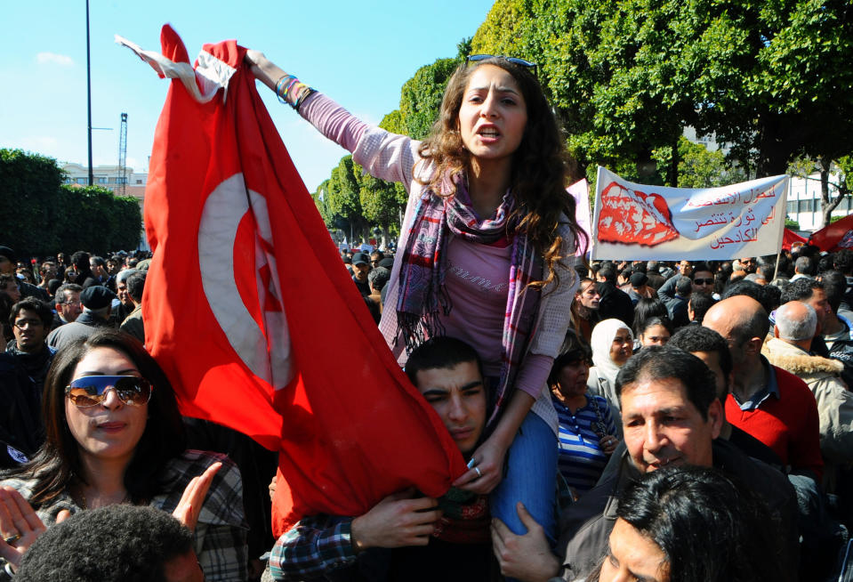 Protestors wave flags and shout slogans during a demonstration to denounce the Islamist-led government, in Tunis, Saturday, Feb 25, 2012. More than 4,000 members of Tunisia's main trade union marched through the center of the capital, prompted by attacks on the union's offices around the country, which it blamed on members of Ennahda, the moderate Islamist party that won elections in October(AP Photo/Hassene Dridi)