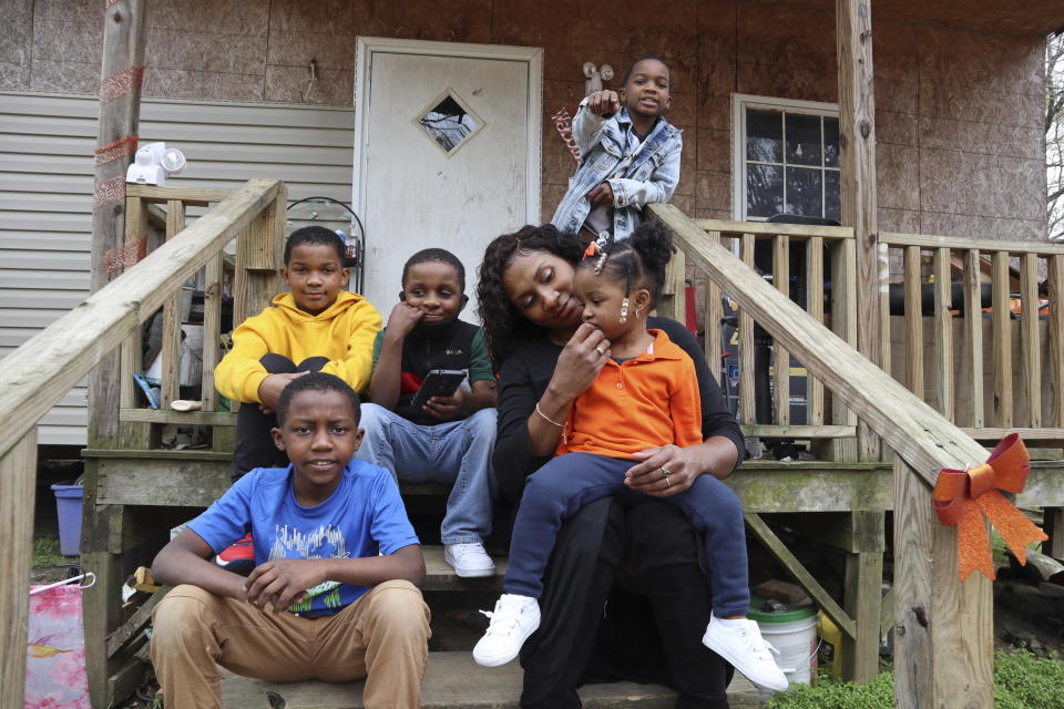 Annie Turner sits with five of her six children, from top left, Kendell Turner Jr., 10; Keydon Turner, 6; Kendrell Turner, 9; Kemiya Turner, 2, and Kejuan Turner, 8, in front of their home in Fayette, Miss., on Monday, March 22, 2021. She said receiving food from the school helps supplement what she is able to provide. It's tough being the family's breadwinner during a pandemic. "It's really put a strain on me — big time." (AP Photo/Leah Willingham)
