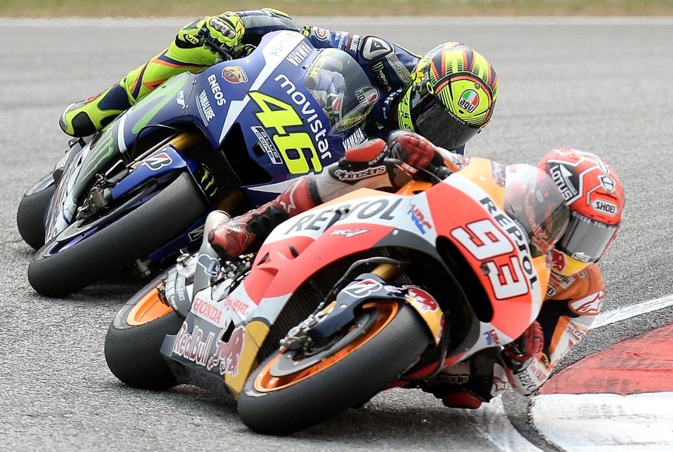 Movistar Yamaha MotoGP's Italian rider Valentino Rossi (L) chases Repsol Honda Team's Spanish rider Marc Marquez (R) during the 2015 MotoGP Malaysian Grand Prix at the Sepang International Circuit on October 25, 2015.     AFP PHOTO / MANAN VATSYAYANA        (Photo credit should read MANAN VATSYAYANA/AFP via Getty Images)