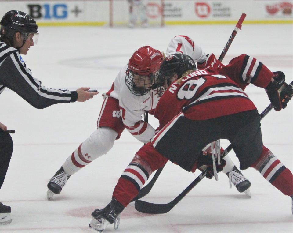 Wisconsin's Jesse Compher (7) and St. Cloud State's Jenniina Nyland face off at LaBahn Arena in Madison, Wis. on Saturday Feb. 4, 2023.