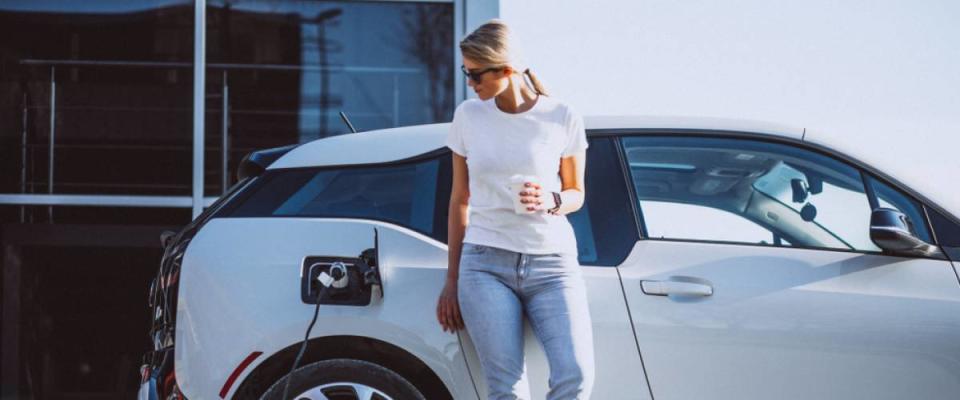 Woman charging electro car at the electric gas station