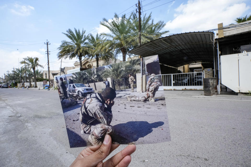 A photograph of Iraqi Army soldier helping a wounded colleague moments after a suicide bomber attack on a celebration marking Iraqi Army Day in the Karradah neighborhood of central Baghdad, Iraq on Sunday, Jan. 6, 2008, is inserted into the scene at the same location Tuesday, March 21, 2023. At least eight people died in the blast. (AP Photo/Hadi Mizban)