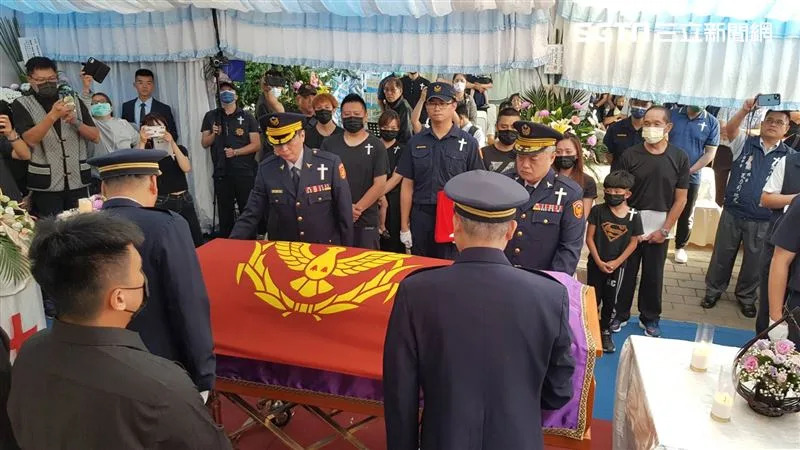 同僚在高姓警員棺木覆蓋警旗。（圖／翻攝畫面）