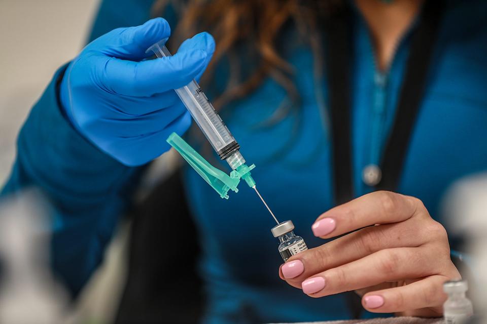 Maysaa Bazzi, 28, of Dearborn works for the Wayne County Health Department and prepares COVID-19 Pfizer vaccines for the nurses to administer at the Wayne County Community College District Downriver Campus in Taylor, Mich. on Feb. 6, 2021. As many as 2,000 K-12 staff are scheduled to get vaccines Saturday, as part of the first week of vaccination efforts for educators in the county. The shots will be given inside the building, but only 300 people can be indoors at once and still maintain social distancing.