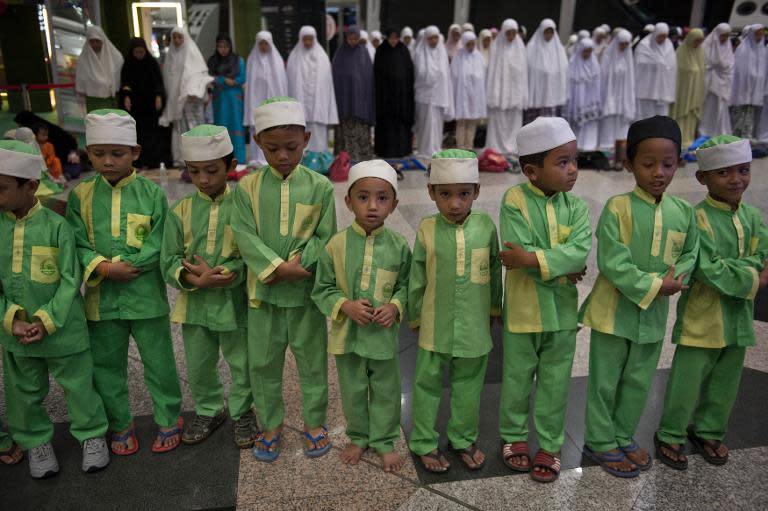 Malaysian Muslim children offer prayers for passengers of the missing Malaysia Airlines flight MH370 plane at Kuala Lumpur International Airport in Sepang on March 13, 2014