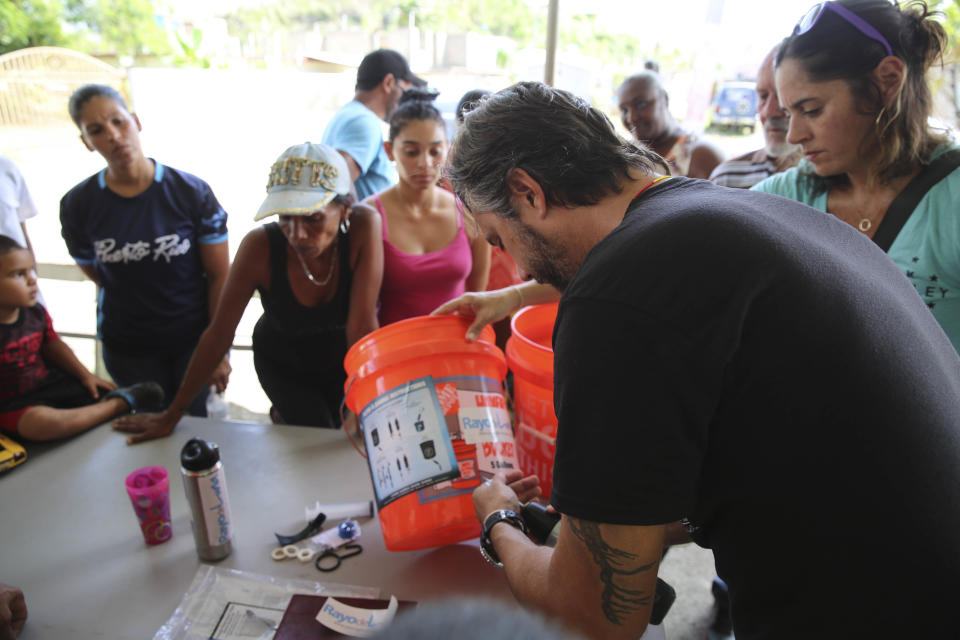 A non-profit organization shows residents in Villa Hugo 2 how to use the donated filters they brought them. Can&oacute;vanas, Puerto Rico. October 14, 2017.