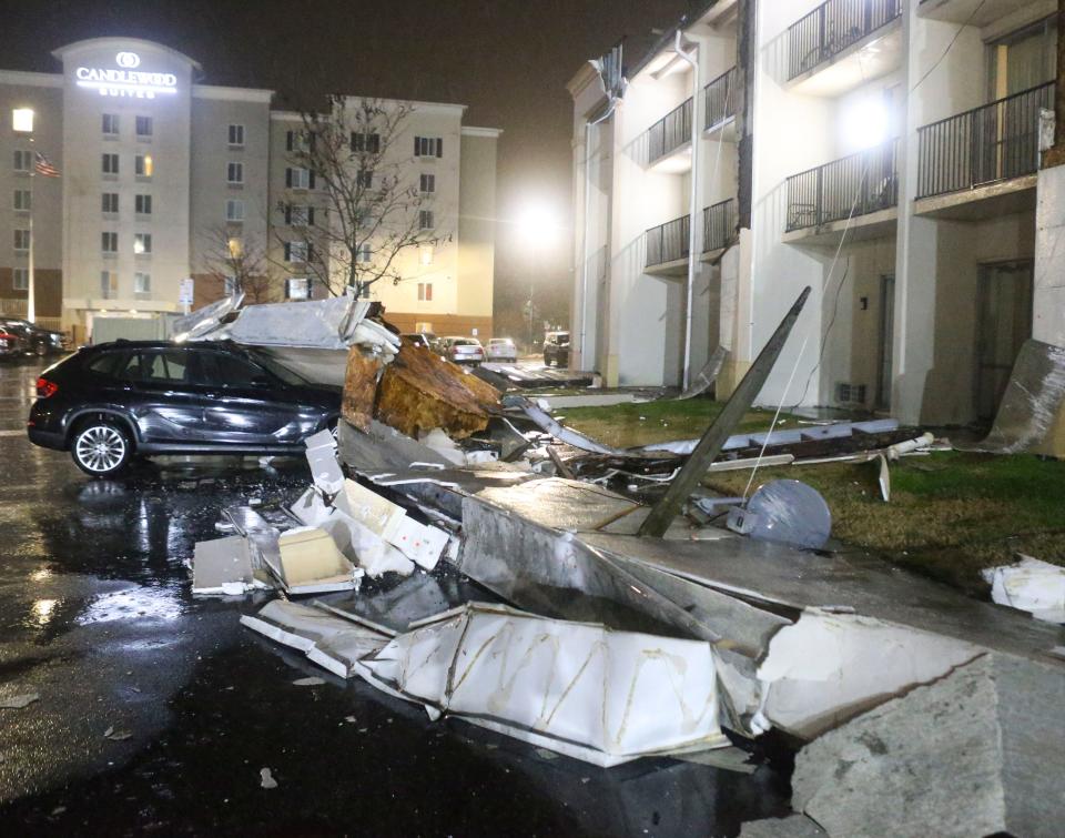 A vehicle sits under debris after a portion of the facade of a wing of the Red Roof Inn on South College Avenue in Newark collapsed as a powerful storm of wind and rain hit Delaware, Tuesday, Jan. 9, 2024.