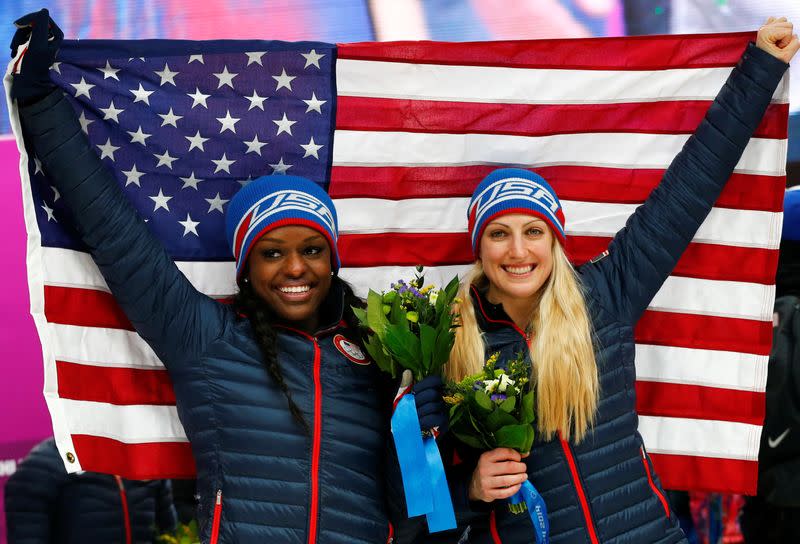 FILE PHOTO: Pilot Greubel and Evans of the U.S. pose with a national flag during the flower ceremony for the women's bobsleigh event at the 2014 Sochi Winter Olympics