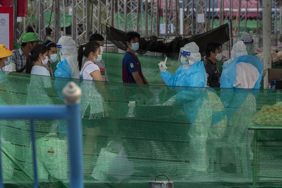 Medical staff in personal protective clothes register migrant workers and their families at a field hospital for COVID-19 patents in Samut Sakhon, South of Bangkok, Thailand, Monday, Jan. 4, 2021. For much of 2020, Thailand had the coronavirus under control. After a strict nationwide lockdown in April and May, the number of new local infections dropped to zero, where they remained for the next six months. However, a new outbreak discovered in mid-December threatens to put Thailand back where it was in the toughest days of early 2020. (AP Photo/Gemunu Amarasinghe)