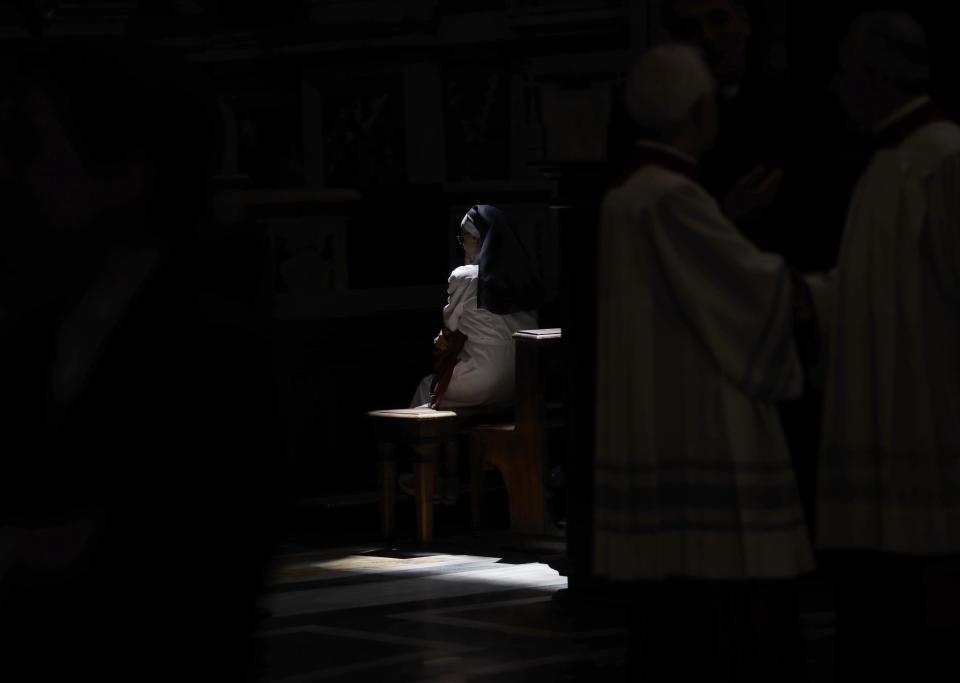 FILE - In this Tuesday, June 26, 2018 file photo, a ray of sun sheds light on nun sitting inside the Basilica of St. John Lateran in Rome. The Vatican is facing a dilemma after nearly all the nuns in a tiny French religious order threatened to renounce their vows rather than accept the removal of their superior. The standoff marks an extraordinary battle of wills between the Vatican and the group of 39 nuns who run homes for the aged in rural France. (AP Photo/Alessandra Tarantino, File )