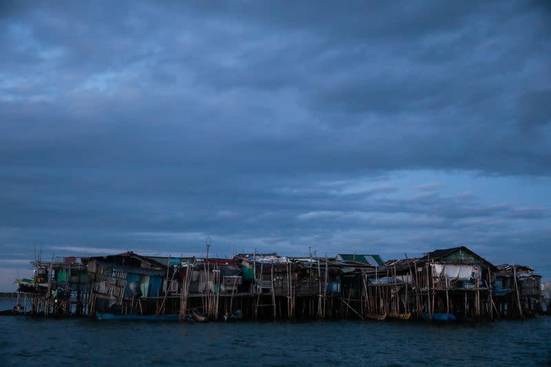 The Wider Image: Rising seas threaten early end for sinking village in Philippines