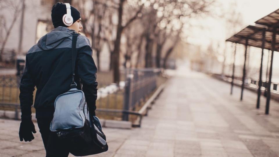 A man carries a travel bag over his shoulder