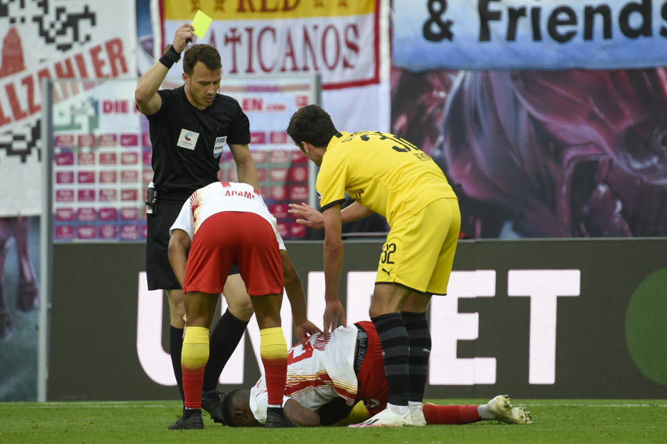 Dortmund's Giovanni Reyna, right, receives a yell card during the German Bundesliga soccer match between RB Leipzig and Borussia Dortmund in Leipzig, Germany, Saturday, June 20, 2020. (AP Photo/Jens Meyer, Pool)