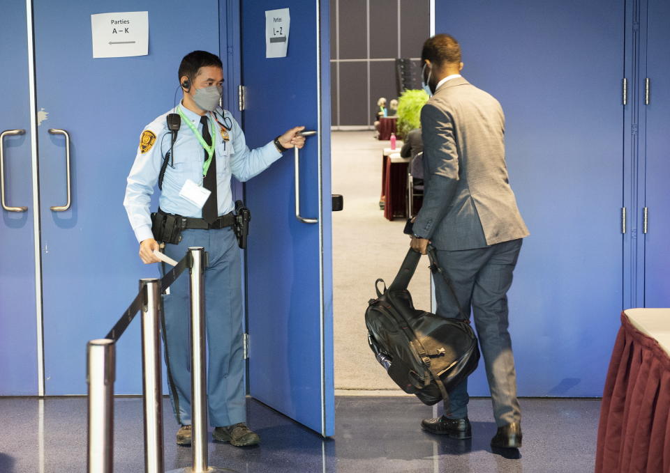 A United Nations security officer opens the door for a delegate into a negotiating room at the COP 15 the UN Biodiversity Conference in Montreal, Sunday, Dec. 18, 2022. (Graham Hughes/The Canadian Press via AP)