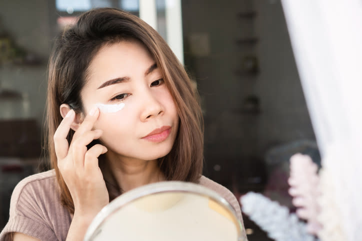 A model applying eye cream