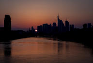 The sun sets behind the buildings of the banking district in Frankfurt, Germany, Saturday, March 28, 2020. Due to the coronavirus the economy expects heavy losses worldwide. For most people, the new coronavirus causes only mild or moderate symptoms, such as fever and cough. For some, especially older adults and people with existing health problems, it can cause more severe illness, including pneumonia.(AP Photo/Michael Probst)