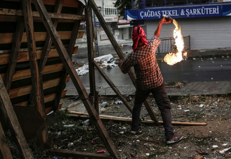 A left wing protestor throws a molotov cocktail towards police during a demonstration denouncing a police operation against Kurdish militants, on July 24, 2015 in Gazi district in Istanbul