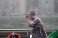 <p>A man shields himself with his plastic poncho during heavy winds and rain brought on by Typhoon Hato in Hong Kong on Aug. 23, 2017. (Photo: Anthony Wallace/AFP/Getty Images) </p>