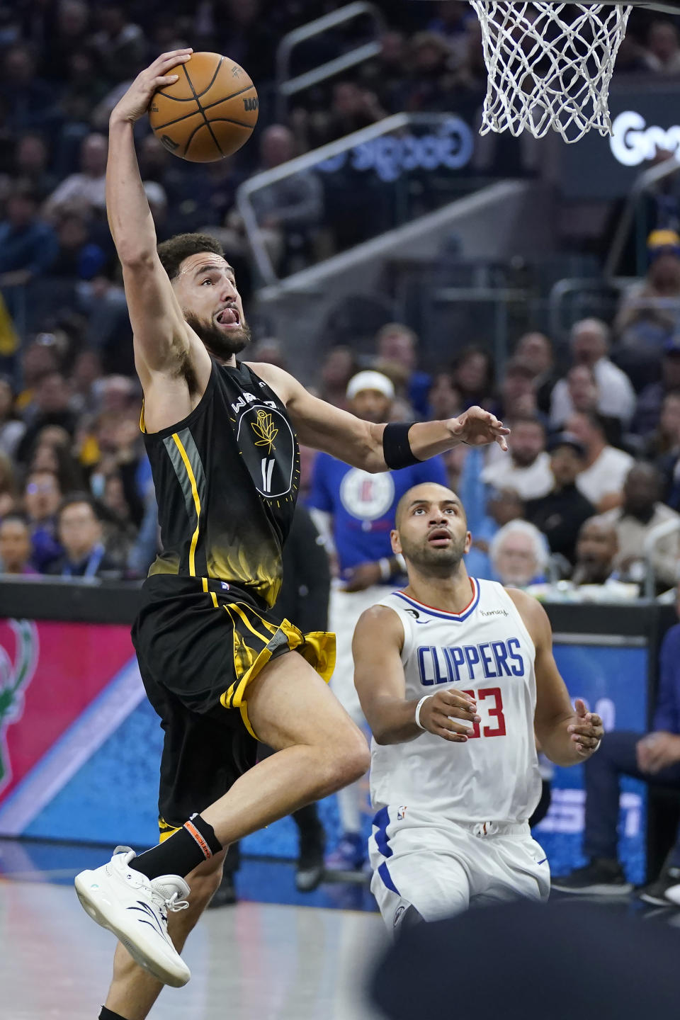 Golden State Warriors guard Klay Thompson (11) dunks in front of Los Angeles Clippers forward Nicolas Batum (33) during the first half of an NBA basketball game in San Francisco, Wednesday, Nov. 23, 2022. (AP Photo/Jeff Chiu)