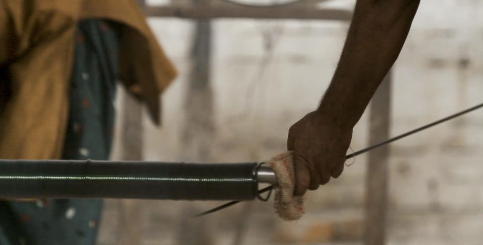 a worker uses his bare hands to remove bangles from the furnace