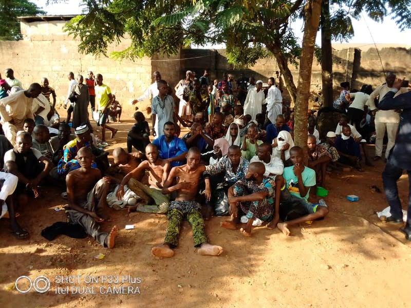 People sit on the ground after being freed by police from an Islamic rehabilitation centre in Ibadan