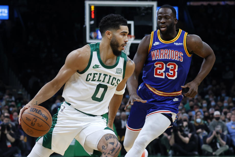 Boston Celtics forward Jayson Tatum (0) drives against Golden State Warriors forward Draymond Green (23) during the first half of an NBA basketball game, Friday, Dec. 17, 2021, in Boston. (AP Photo/Mary Schwalm)