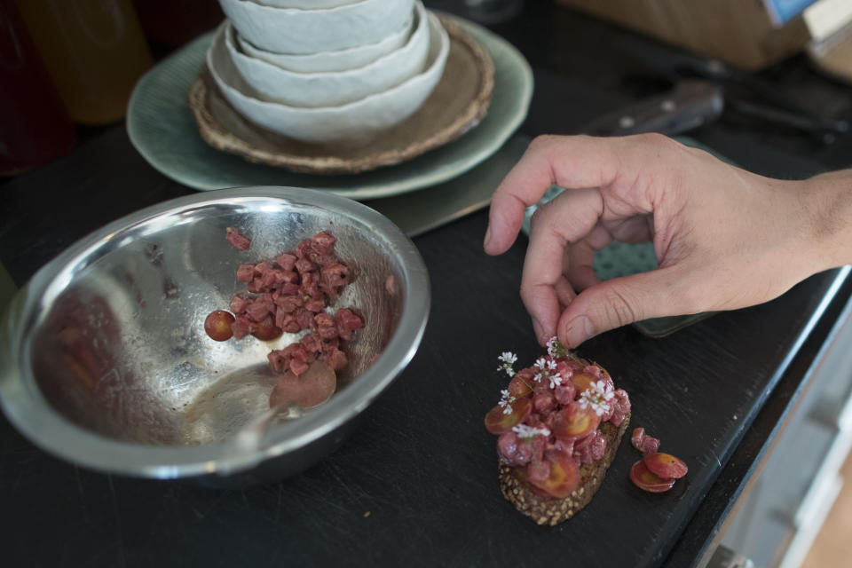 In this May 17, 2019 photo, Jonah Reider prepares a beef tartare toast appetizer during a Pith dinner in New York. Reider’s informal kitchen training started during childhood in Newton, Massachusetts, in a family that cooked far-from-ordinary meals. (AP Photo/Mary Altaffer)