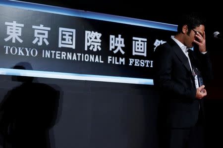 Iranian director Amirhossein Asgari reacts as he receives the Best Asian Future Film Award for his film "Borderless" during the closing ceremony of the Tokyo International Film Festival in Tokyo October 31, 2014. REUTERS/Yuya Shino