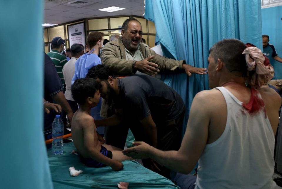 Wounded Palestinians sit at a hospital in Gaza.