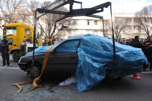 Iranian security forces inspect the site where a magnetic bomb attached to a car by a motorcyclist exploded outside a university in Tehran. The assassination of an Iranian nuclear scientist sparked deep fury in Tehran on Thursday against prime suspect Israel and against the United States, which said it had nothing to do with the murder