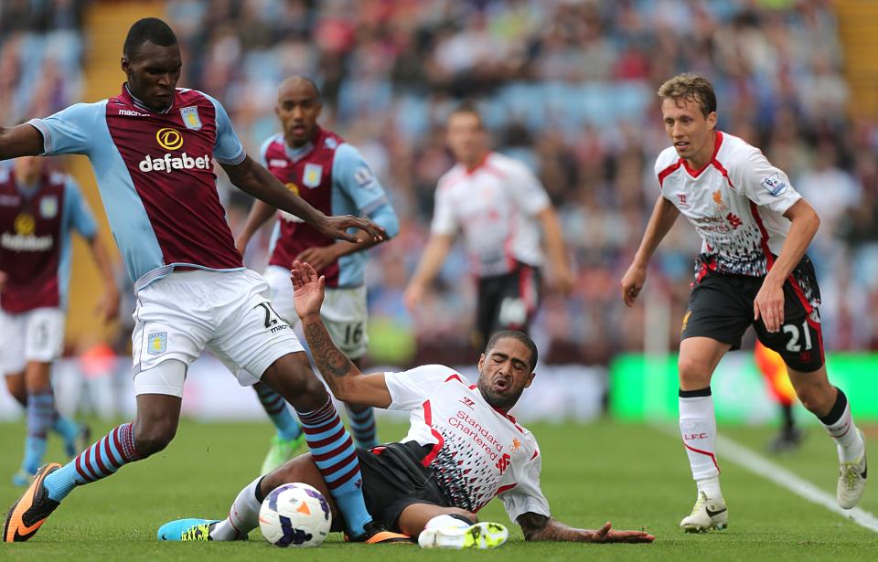 Liverpool's Glen Johnson (centre) slides in on Aston Villa's Christian Benteke (left) as Leiva Lucas (right) looks on