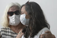 Beatriz Matos, right, is consoled during the funeral of husband Indigenous expert Bruno Pereira, at the Morada da Paz cemetery, in Recife, Pernambuco state, Friday, June 24, 2022. Pereira was killed in the Amazon region with the British journalist Dom Phillips. (AP Photo/Teresa Maia)