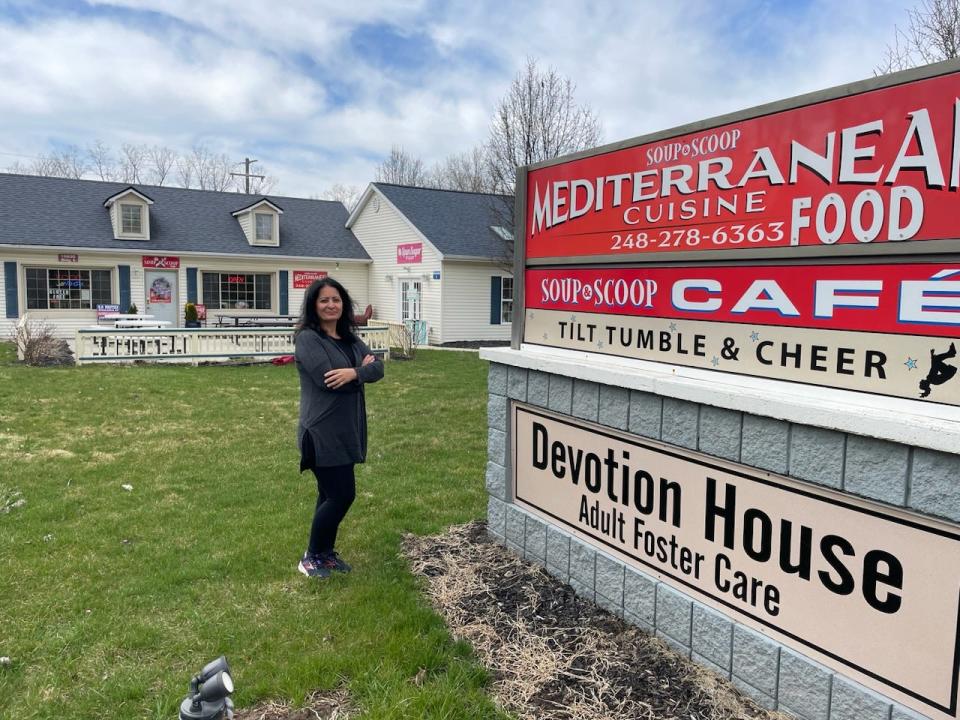 Susie Ansara stands near her eatery's sign on Rushton Road in Green Oak Township near South Lyon and Brighton on Thursday, April 6, 2023.