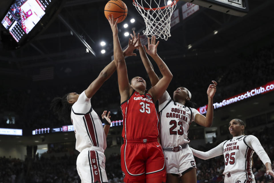 Georgia forward Javyn Nicholson (35) shoots over South Carolina forward Ashlyn Watkins, left, and guard Bree Hall (23) during the first half of an NCAA college basketball game, Sunday, Feb. 18, 2024, in Columbia, S.C. (AP Photo/Artie Walker Jr.)