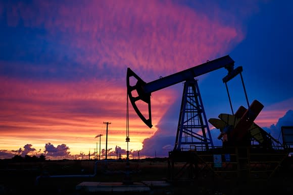 An oil pump with a beautiful sunset in the background.