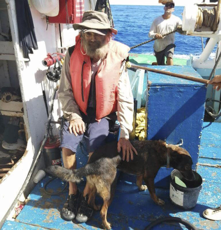 Timothy Shaddock sits with his dog, Bella, after being rescued. 