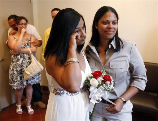 Same-sex couple Mishan Moore (L), 39, wipes a tear as her partner Jacqueline Rodriguez, 34, looks on during their wedding ceremony at Queens Borough Hall in New York July 24, 2011.