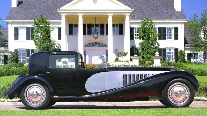 A photo of a vintage Bugatti Royale parked outside a large house. 