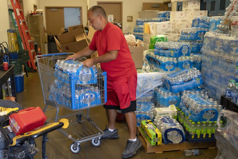 Jerry Roberts carga un carrito con agua embotellada en el Salvation Army Tucson Hospitality House en Tucson, Arizona, el lunes 17 de julio de 2023. 