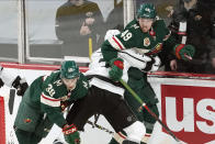 Minnesota Wild's Ryan Hartman, left, chases the puck as Los Angeles Kings' Matt Roy, center, checks Minnesota Wild's Victor Rask into the boards in the second period of an NHL hockey game, Tuesday, Jan. 26, 2021, in St. Paul, Minn. (AP Photo/Jim Mone)