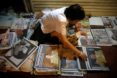 A vendor arranges newspapers carrying headlines of the passing of Thailand's King Bhumibol Adulyadej in Bangkok, Thailand October 14, 2016. REUTERS/Edgar Su