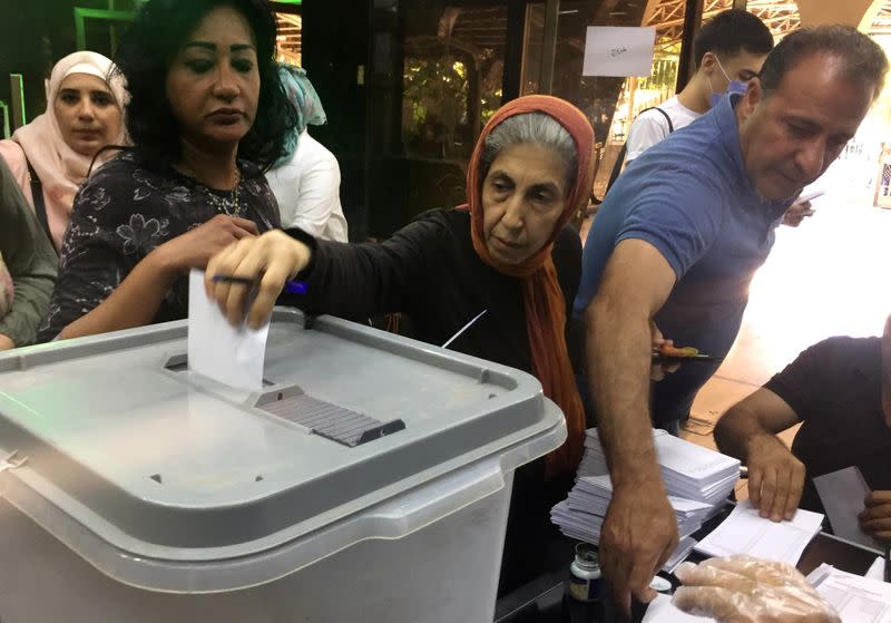 A woman casts her vote inside a polling station during the parliamentary elections in Damascus