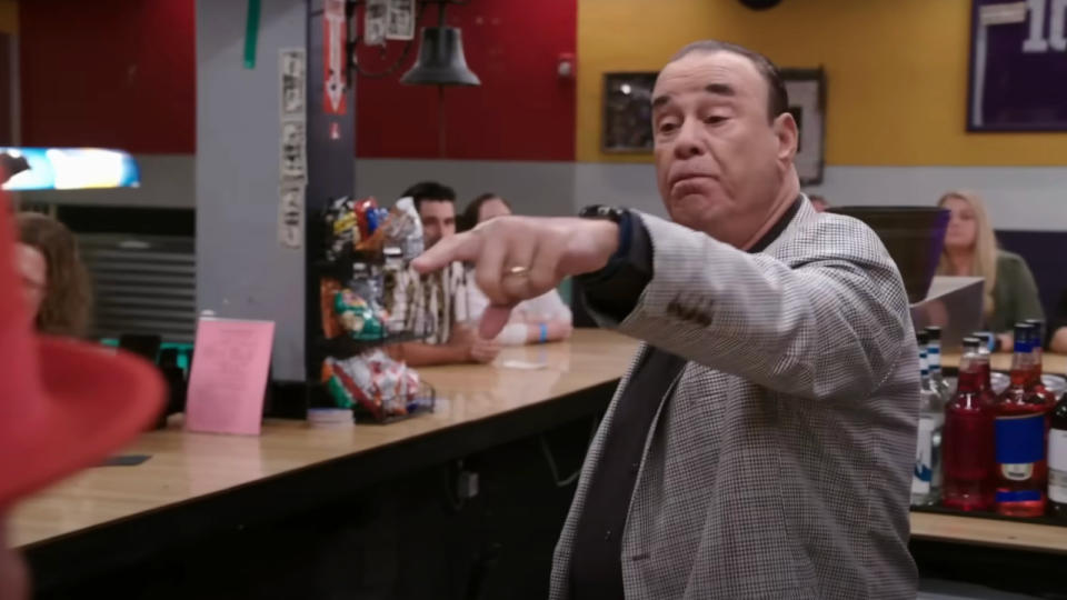 Jon Taffer points at a patron from behind the bar during a visit on Bar Rescue.