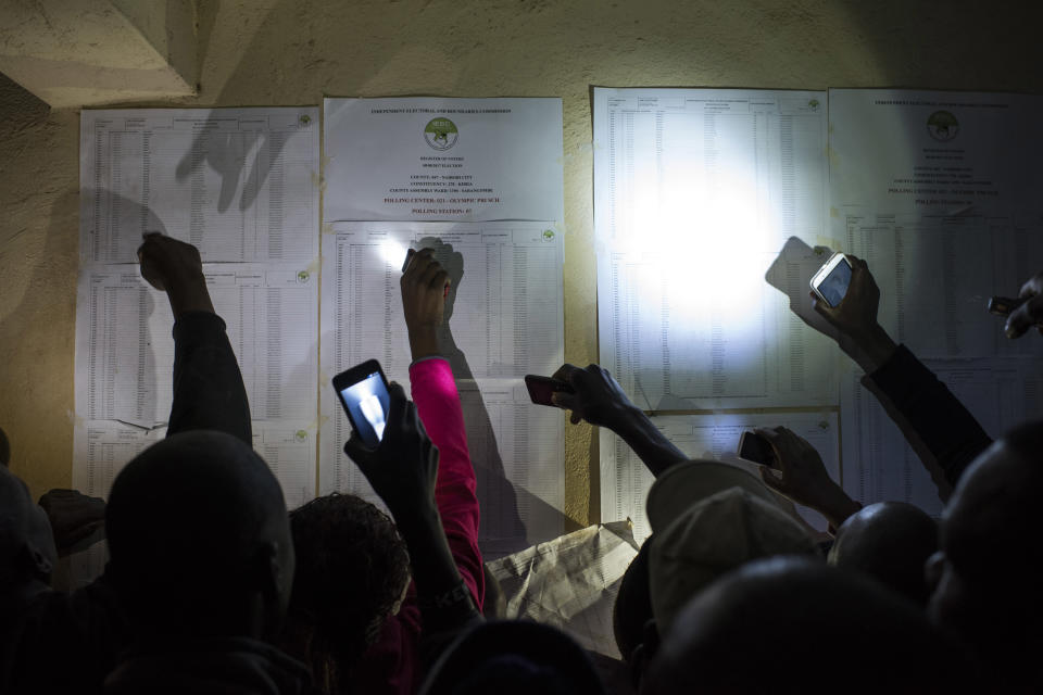 <p>People check names on a voter registration list at the Olympic Primary School in Kibera, one of the largest slums in Africa, on Aug. 8, 2017 in Nairobi, Kenya. (Photo: Andrew Renneisen/Getty Images) </p>