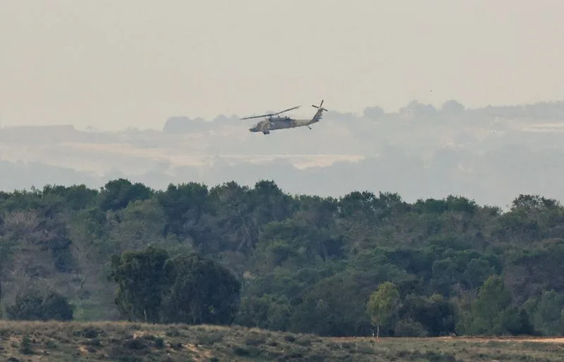 An Israeli military helicopter flies near the Israel-Gaza border, amid the ongoing conflict between Israel and the Palestinian Islamist group Hamas, as seen from southern Israel