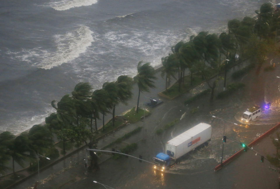 Motorists drive their vehicles through the floods which was brought about by Typhoon Mangkhut that barreled into northeastern Philippines before dawn Saturday, Sept. 15, 2018 in Manila, Philippines. The typhoon slammed into the Philippines' northeastern coast early Saturday, its ferocious winds and blinding rain ripping off tin roof sheets and knocking out power, and plowed through the agricultural region at the start of the onslaught. (AP Photo/Bullit Marquez)