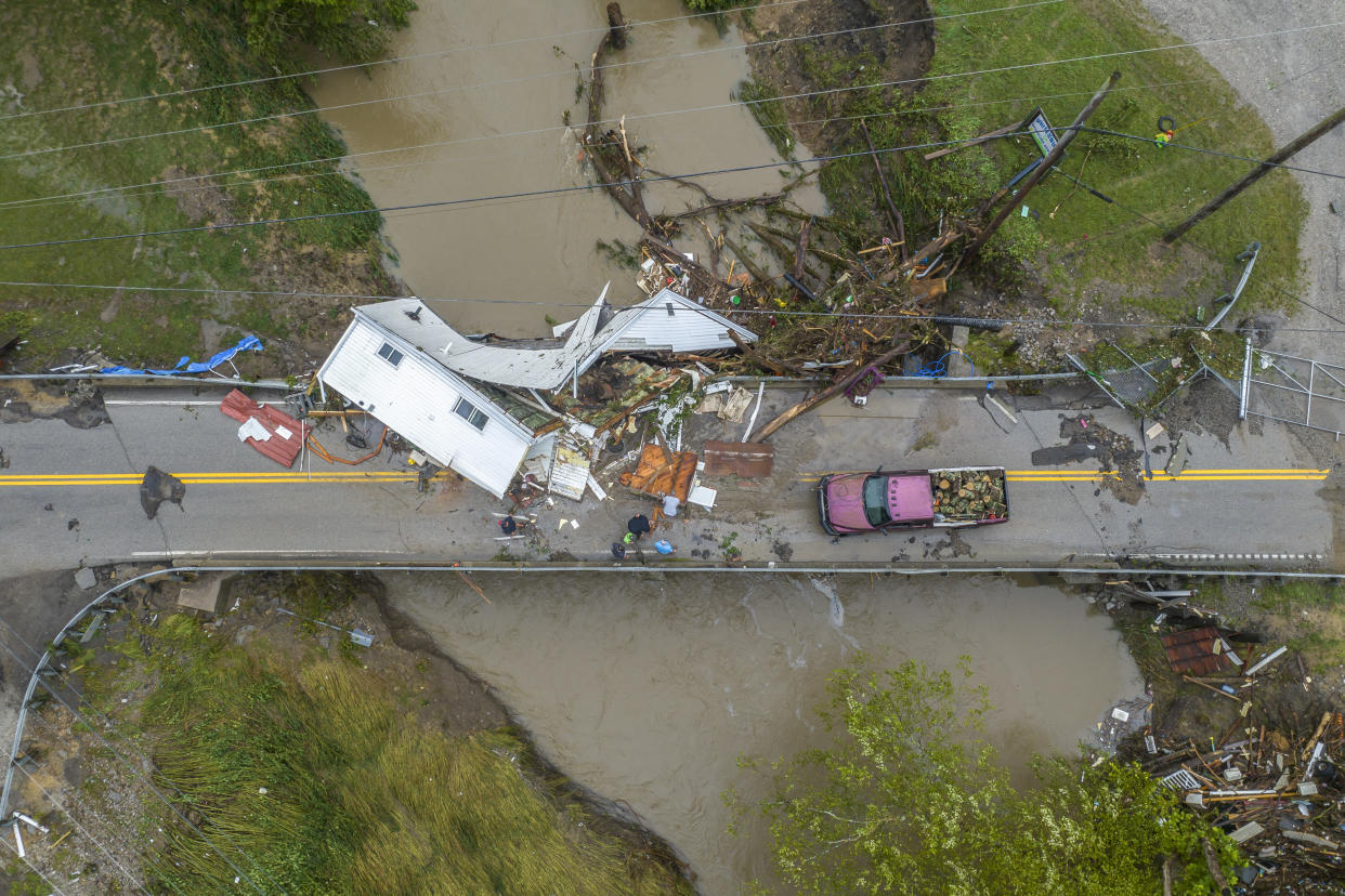 People work to clear a house from a bridge in Letcher County, Ky. (AP)