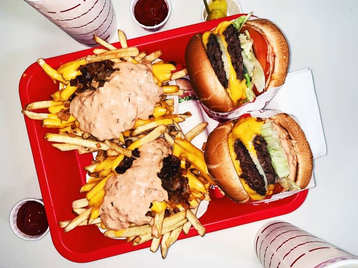 burgers and sauce-covered fries on a lunch tray