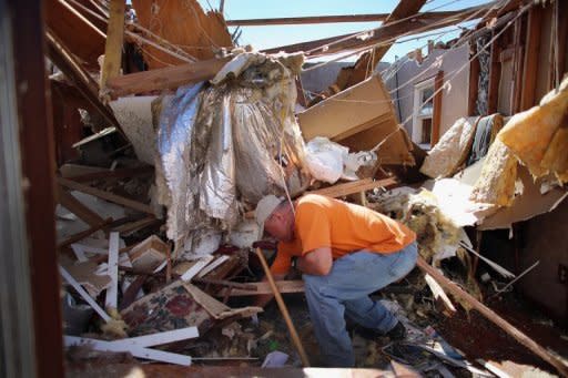 A man salvages items from what was the living room of his home after it was damaged by a tornado on June 2, 2013 in El Reno, Oklahoma. A series of tornadoes battered Oklahoma with high winds, heavy rain and large hail, causing at least 11 fatalities in a state already reeling from a monster twister that claimed two dozen lives last month